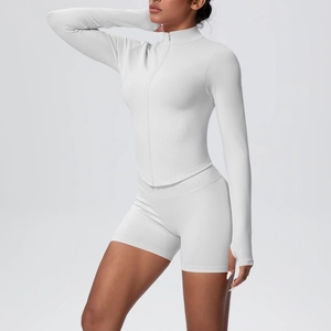 Détail du tissu en maille côtelée blanche de la veste zippée et du short de yoga