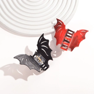 Close-up of bat-shaped hair claws in black and red marble texture with metal springs
