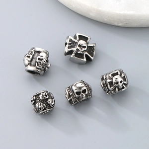 Macro shot of silver retro titanium steel skull and cross spacer beads for DIY jewelry