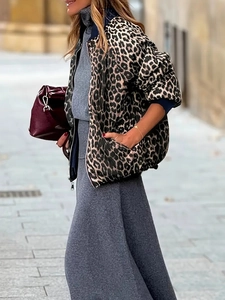 Detail of leopard print reversible bomber jacket styled with knit skirt and handbag