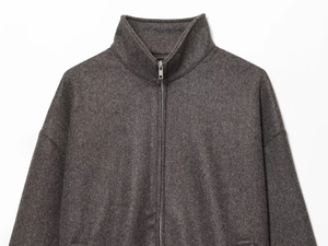 Close-up of charcoal gray bomber jacket showing soft fleece texture and stand collar zipper