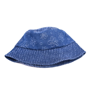 Blue denim bucket hat with white flower prints and frayed brim on a white background