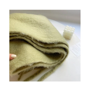Close-up of soft light green plush scarf showing thick knit texture and fluffy material