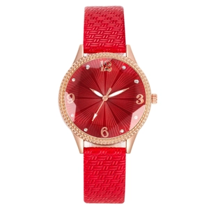 Dettaglio dell'orologio con quadrante rosso soleil e cinturino a trama intrecciata