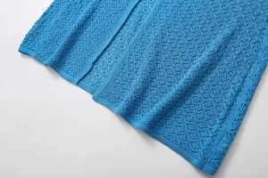 Detailed view of royal blue knit fabric featuring intricate diamond crochet patterns