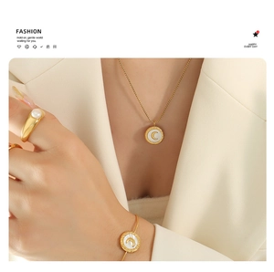 Close-up of gold moon shell jewelry set featuring necklace and pearl ring on model