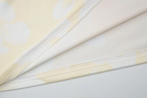 Close-up of yellow floral fabric showing soft texture and premium stitching detail