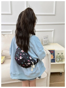 Detail of a kids' black waist bag featuring cute colorful bow and rabbit prints