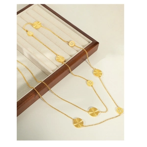 Close-up of double-layer gold necklace with textured and stone-set round pendants
