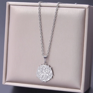 Macro shot of silver stainless steel goat pentagram pendant on a luxury beige gift box
