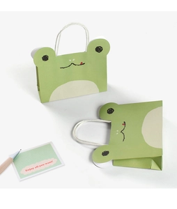 Detail of green frog cartoon paper gift bag with 3D eyes and white handle for kids