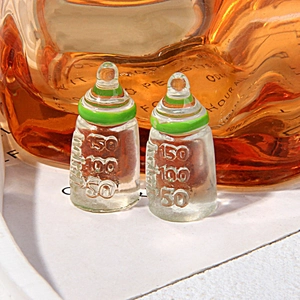 Macro shot of miniature resin feeding bottles with green rings and relief scale markings