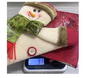 Detailed weight display showing the plush snowman Christmas stocking at 93g on a digital scale