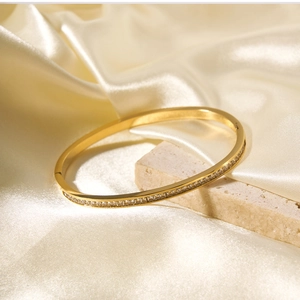 Dettaglio del bracciale rigido placcato oro 18k con scintillanti zirconi bianchi