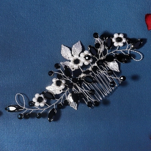 Detailed view of handmade silver hair comb with white pearls and black crystal flowers