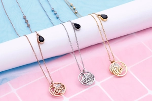 Detailed view of three necklaces with Peace pendants in rose gold, silver and gold finishes
