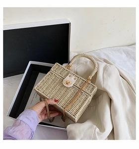 Detail der gewebten Strohhandtasche mit Lederklappe und goldener Metallkette