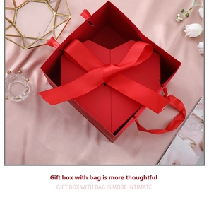 Macro shot of red heart-shaped gift box with matching square outer case and silk ribbons