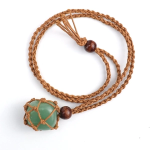 Detailed view of green natural stone pendant in brown handcrafted woven rope net