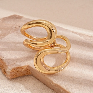 Macro shot of abstract intertwined gold geometric rings on a stone texture background