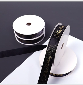 Detail of black satin ribbon with elegant gold Happy Birthday lettering for gift wrapping