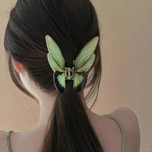 Détail de la pince à cheveux papillon vert élégant avec des textures d'ailes translucides