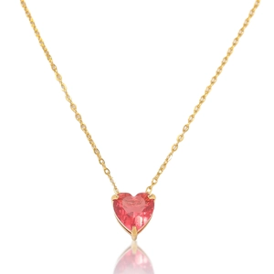 Macro view of a heart-shaped pink zircon pendant on a delicate gold-plated chain necklace