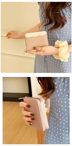Detailed view of pink and beige lychee textured leather coin purse with metal zipper
