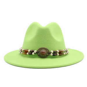 Close-up of neon green fedora hat featuring a white beaded band and vintage bronze buckle