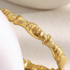 Macro detail of 18K gold plated stainless steel bracelet with textured fish bone pattern