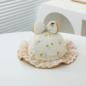 Detailed view of baby sun hat with fruit print, large bow and white lace trim