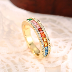 Macro shot of gold eternity ring with rainbow square stones and white side crystals