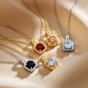 Close-up of square zircon pendant necklaces in multiple colors on silk fabric
