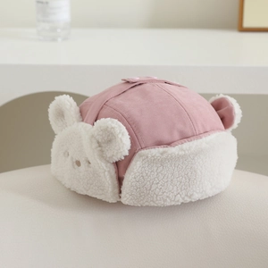Detailed view of pink winter trapper hat with lamb wool lining and cute bear embroidery