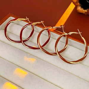 Set of four gold-plated wave-shaped hoop earrings with colorful enamel drip glaze detail