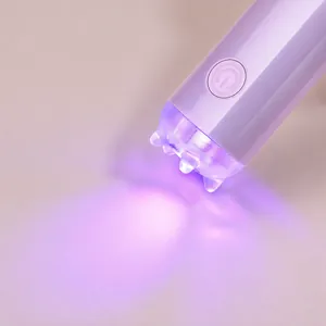 Macro view of purple handheld UV nail lamp featuring convex lens and power button