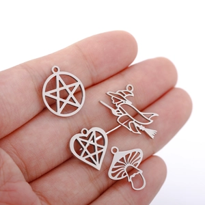 Handheld view of silver witch and ghost pendants for DIY jewelry making