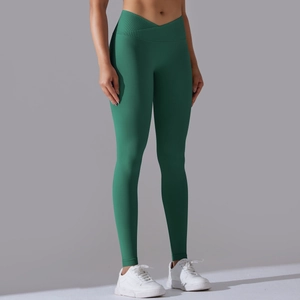 Dettaglio dei leggings yoga verdi senza cuciture con vita a V incrociata e design push-up