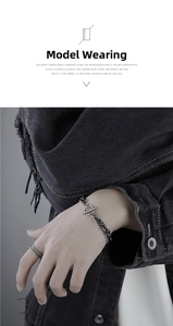 Detail of vintage double-layer titanium steel bracelet with toggle clasp on denim sleeve