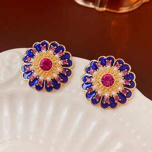 Macro detail of vintage floral earrings with blue enamel, pink crystals and white pearls
