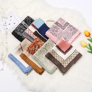 Elegant paisley and geometric print square silk scarves set on soft white plush background
