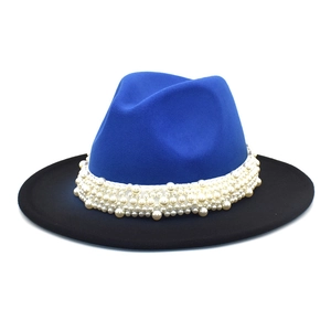 Detail view of a blue and black fedora hat with elegant pearl embellishments and wide brim
