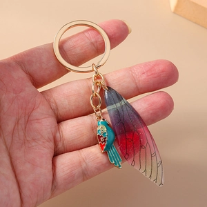 Detail of luxury bird wing keychain with colorful resin cicada wings and gold ring