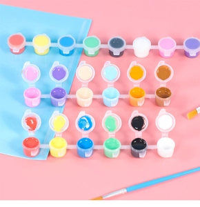 Flat lay of colorful acrylic paint set in small pots with brushes on pink background