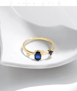 Detailansicht goldener Ring mit blauem Edelstein und flankierenden blauen Akzenten