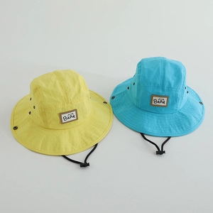 Detail of quick-dry kids bucket hats in yellow and blue with adjustable windproof cords