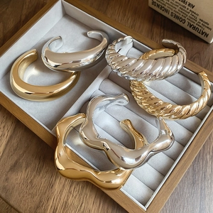 Detailed set of six open bangles in gold and silver finishes with various textures
