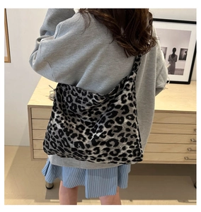 Detailed back view of a person wearing a large grey leopard print canvas tote bag