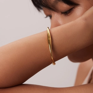 Primo piano di un elegante bracciale a spirale in acciaio inossidabile placcato oro 18 carati
