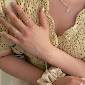 Detailed close-up of 925 sterling silver twisted knot ring and moonstone necklace set